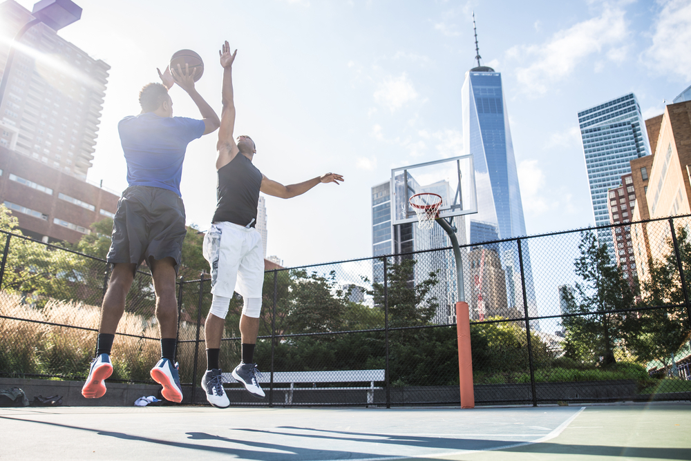 Two men playing basketball outside