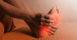 person holding their foot radiating nerve pain