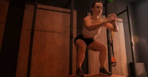 Image of a woman squatting on workout block with a colored overlay