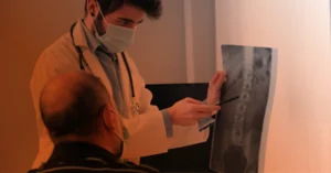 A doctor examines an x-ray with a patient to determine if XLIF surgery is needed