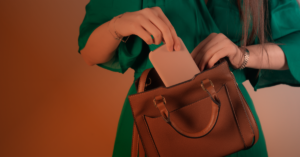 A woman places a phone into her heavy bag.