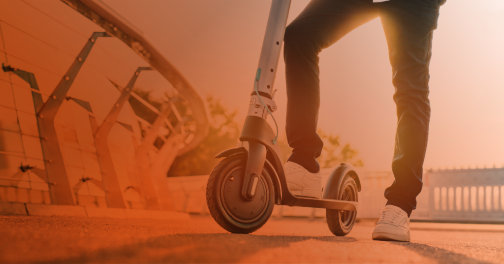 A person getting onto a scooter.