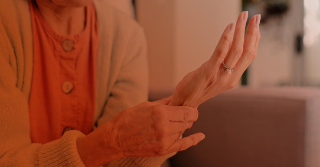 A mature woman with osteoporosis rubs her wrist.