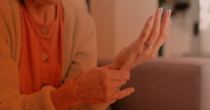 A mature woman with osteoporosis rubs her wrist.